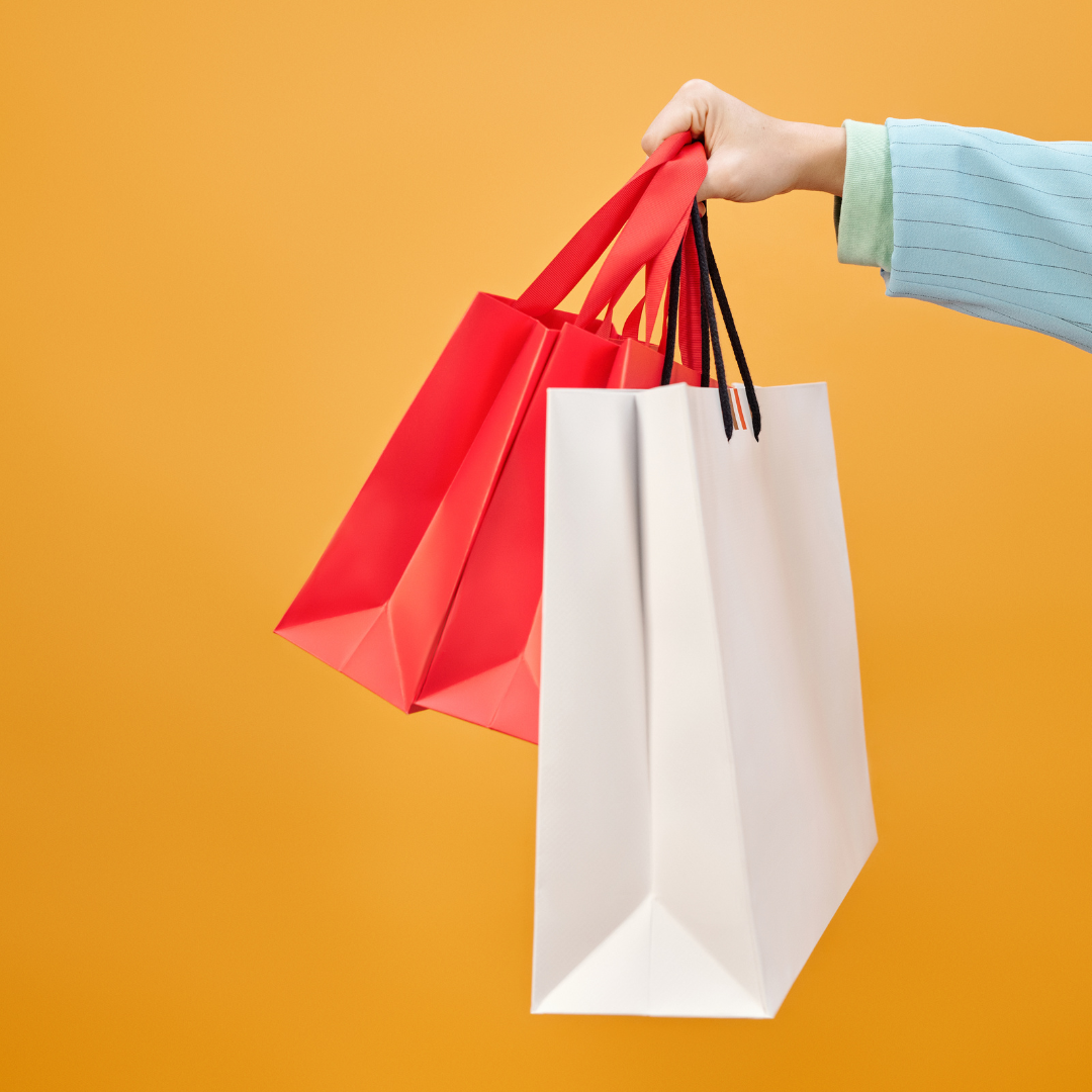 hand holding two shopping bags to symbolize BigCommerce BOPIS