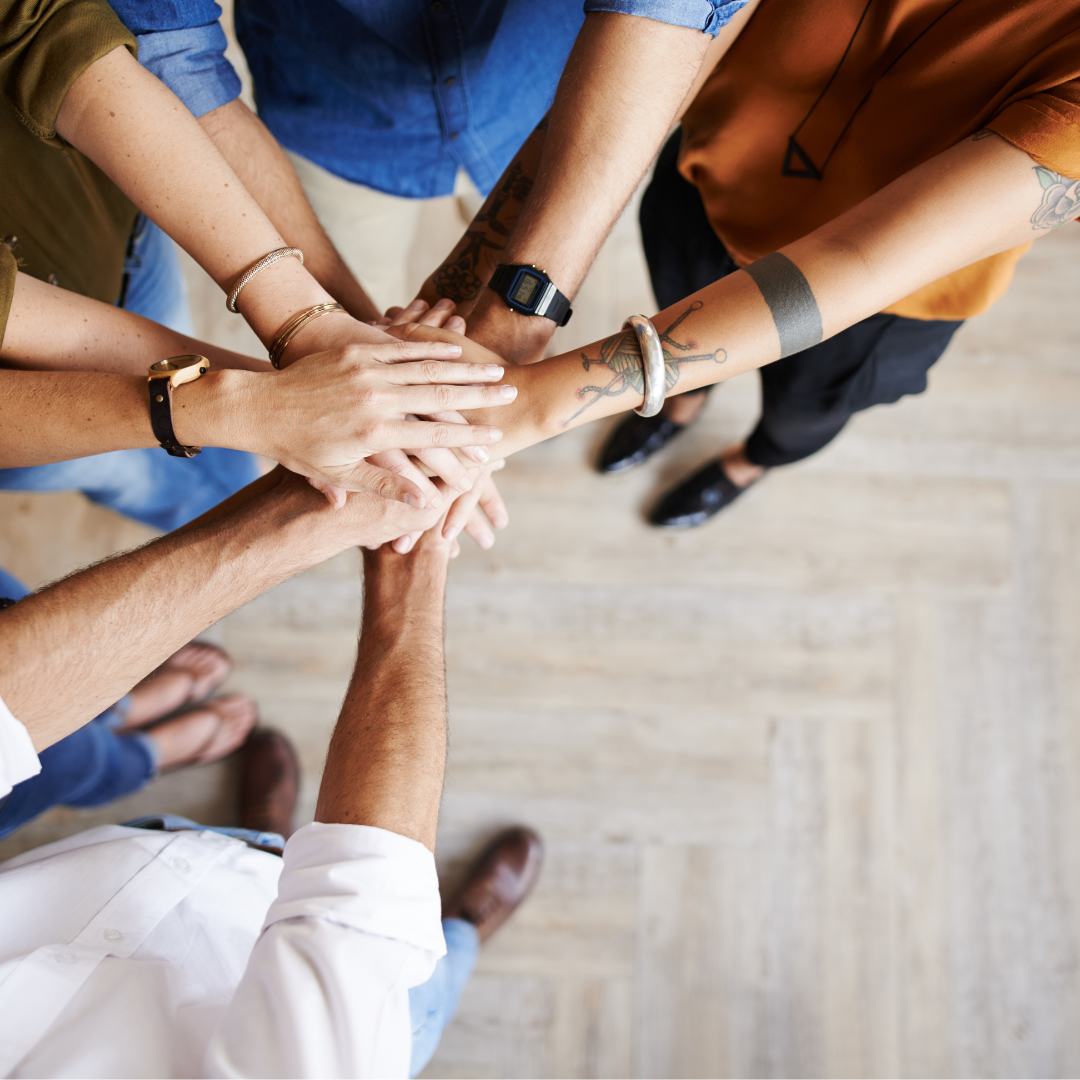 top down angle of a BIgCommerce website designer joining hands with the marketing team of a business