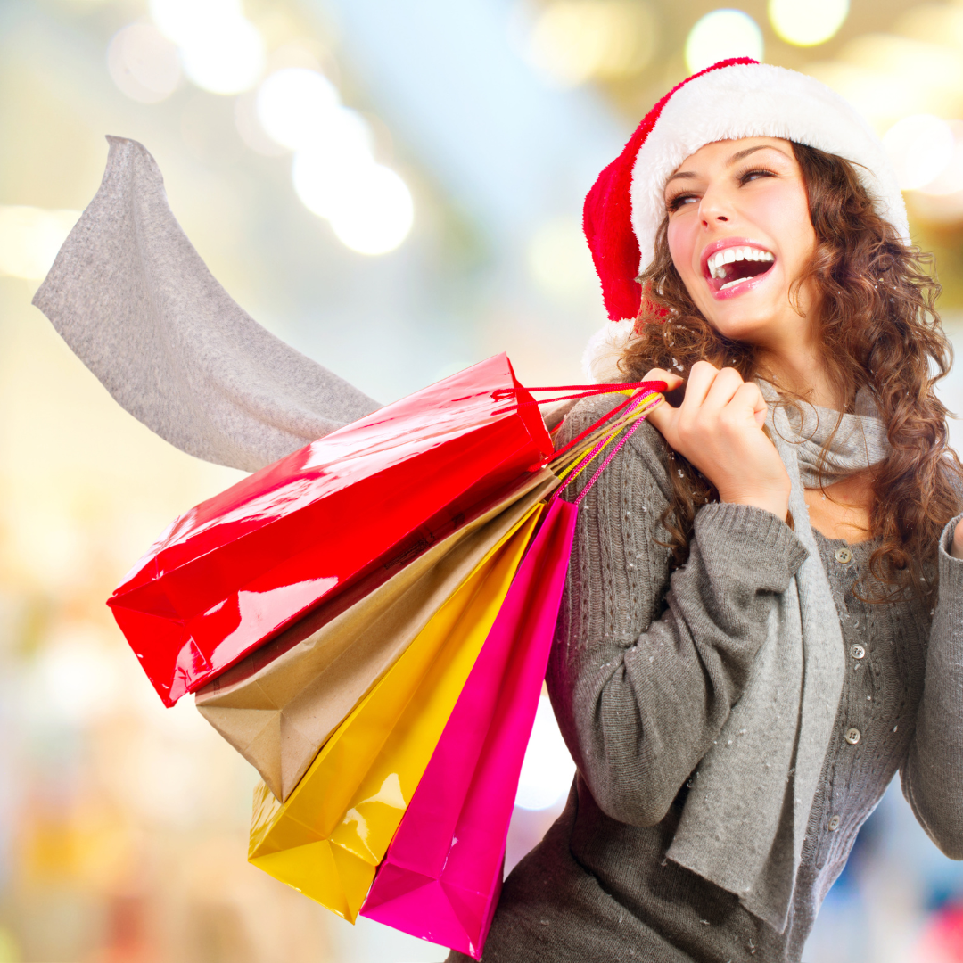 woman wearing a Santa hat and holding shopping bags happy after picking up her BigCommerce BOPIS purchase